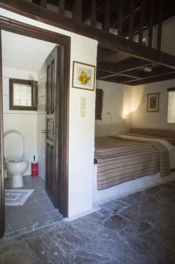 Doppelbett und Badezimmer mit Dusche und Toilette im Obergeschoss