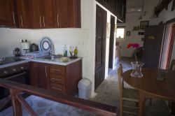 Küche und Essbereich. Rechts am Ende des Raumes der offene Kamin; links das Doppelbett